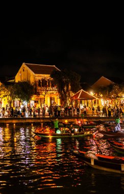 HOI AN, VİETNAM - 8 Şubat 2026: Vietnam 'da geceleri turist feneri nehir tekneleri ile eski bir kasaba nehir manzaralı hoi
