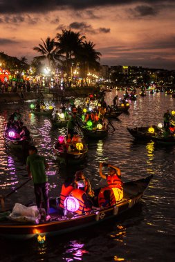HOI AN, VİETNAM - 8 Şubat 2026: Vietnam 'da geceleri turist feneri nehir tekneleri ile eski bir kasaba nehir manzaralı hoi