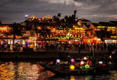 HOI AN, VİETNAM - 8 Şubat 2026: Vietnam 'da geceleri turist feneri nehir tekneleri ile eski bir kasaba nehir manzaralı hoi