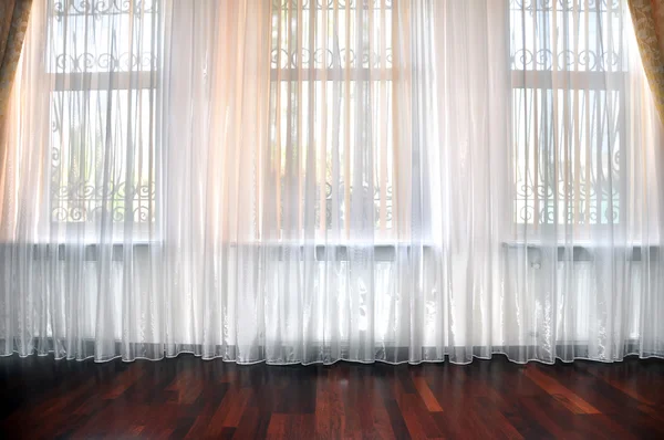 Room window with white, yellow and orange curtains