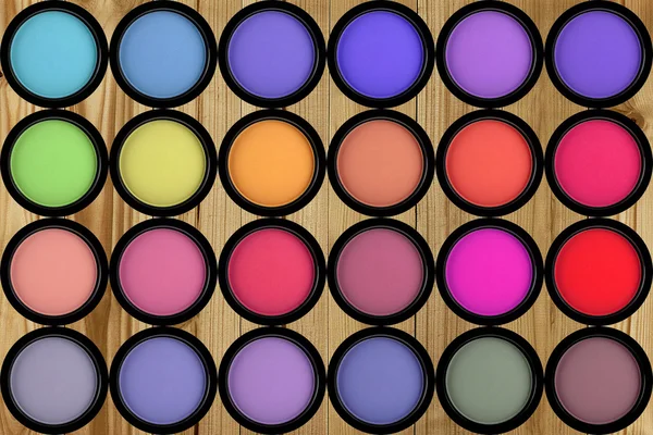 Set multicolored eye shadows on wooden background