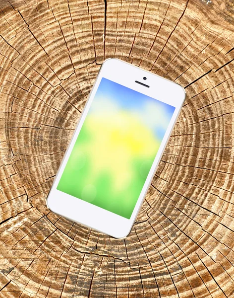 mobile phone with bright screen on wooden cracked background