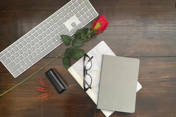 Wood background with black journal and roses