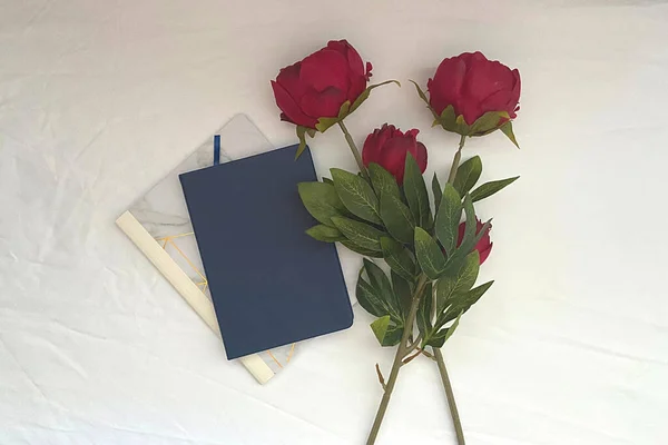 White background with blank book cover and flowers