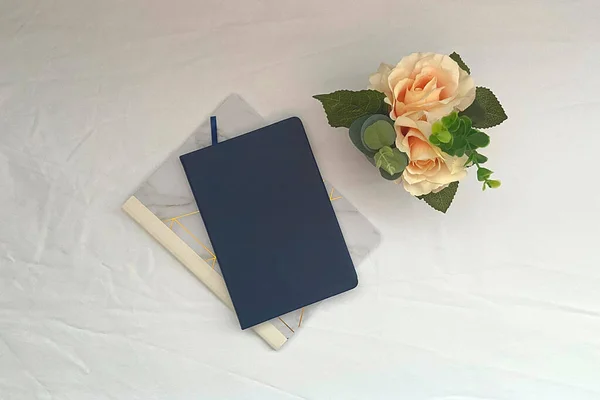 White background with blank book cover and flowers
