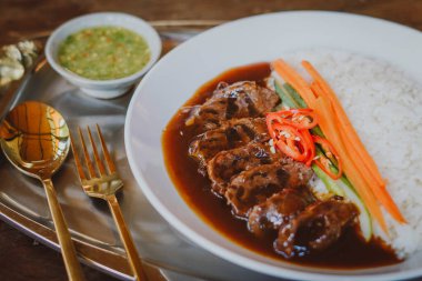 Beyaz pirinç ve soslu sığır güveci.