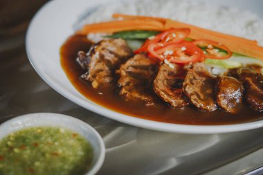 Beyaz pirinç ve soslu sığır güveci.