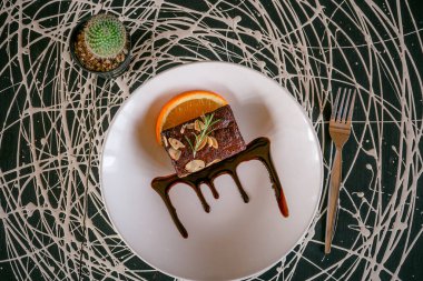 Tahtada portakal kabuğuyla süslenmiş taze brovniler.