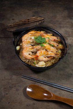 Güveçte karides ve kil kapta vermicelli.