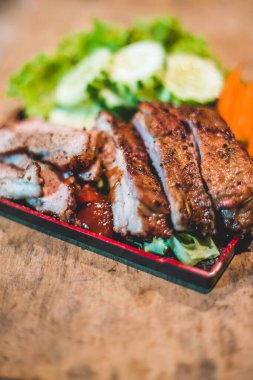 Tütsülenmiş Barbekü Domuz Pirzolası Kesme tahtasında soslu, seçici odaklı