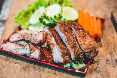 Tütsülenmiş Barbekü Domuz Pirzolası Kesme tahtasında soslu, seçici odaklı