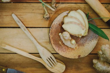 Tahta masada zencefil kökü dilimlenmiş.