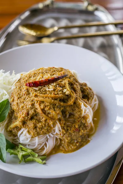 Rice noodles in fish curry sauce with vegetables on the table