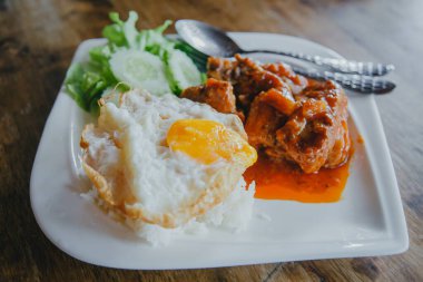 Buharda pişmiş domuz ve pilav ve ahşap masada kızarmış yumurta.