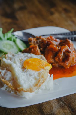 Buharda pişmiş domuz ve pilav ve ahşap masada kızarmış yumurta.