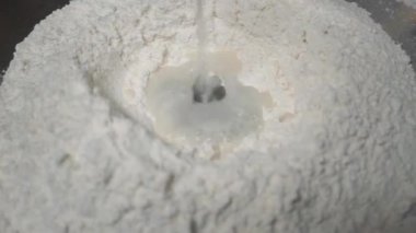 Hamur yoğuran elleri pişir, beyaz buğday unu serpiştir.