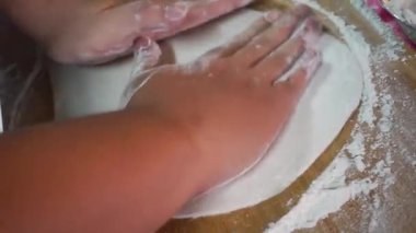 Hamur yoğuran elleri pişir, beyaz buğday unu serpiştir.