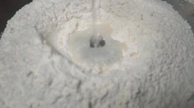 Hamur yoğuran elleri pişir, beyaz buğday unu serpiştir.