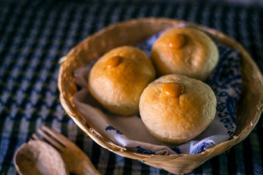 Peçeteli karanlık bir masada ev yapımı ekşi ekmek.