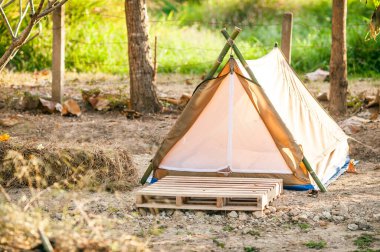 Açık çayırda askeri çadır. Ağaçların arka planına karşı