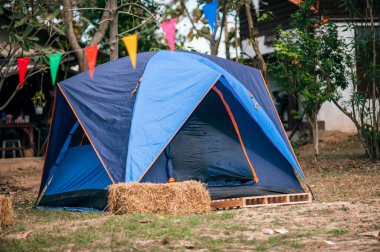 Açık çayırda askeri çadır. Ağaçların arka planına karşı