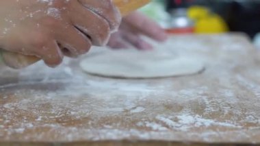 Hamur yoğuran elleri pişir, beyaz buğday unu serpiştir.