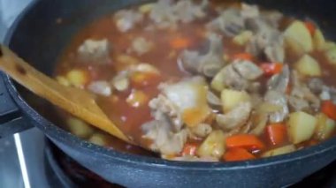 Man cooking and stir hot pork stew.Tasty beef meat stewed with potatoes