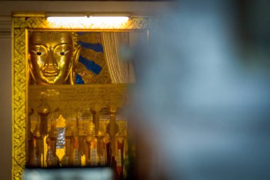 Tayland Tapınağı 'nda sarı ışığı olan Buda heykelinin başı.