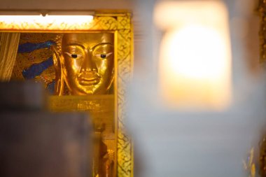 Tayland Tapınağı 'nda sarı ışığı olan Buda heykelinin başı.