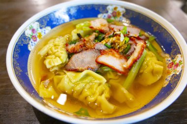 Karidesli erişteli erişte çorbasının olduğu bir toprak kabının yakın plan fotoğrafı. Öğle yemeği ya da akşam yemeği için sete koyulmuş.