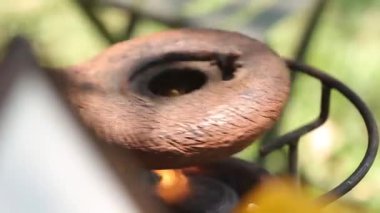 Kahve çekirdekleri, bir eski El değirmeni kavurma için aygıt. Dumanlı kızartma kahve bir ahşap stand. Stüdyo aydınlatma.