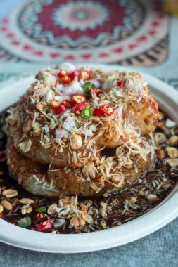 Kavrulmuş hindistancevizi, fıstık, acı biber ve baharatlı sosla kaplanmış Tayland pomelo salatası. 