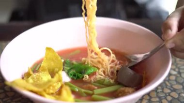 Bir kase Tay Yen Ta Fo şehriye çorbası pembe çorba, balık köftesi, kızarmış wonton, sabah zaferi ve pembe bir kasede servis edilen tofu. Tayland 'da, eşsiz tatlı ve ekşi tadı ile tanınan popüler bir sokak yemeği..