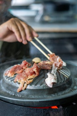 Tayland usulü ızgara tavasına yakın plan, Moo Kratha olarak bilinir, domuz eti, karides ve sebzeli ızgara ve çorba. Tayland 'da popüler Asya yemek deneyimi.