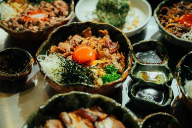 Çiğ yumurta sarısı ile kaplanmış geleneksel Japon sığır eti kasesinin (donburi) yakın çekimi.,