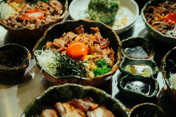 Çiğ yumurta sarısı ile kaplanmış geleneksel Japon sığır eti kasesinin (donburi) yakın çekimi.,