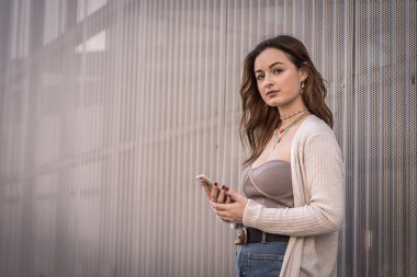 Akıllı telefonlu hoş, düşünceli genç bir kadın.