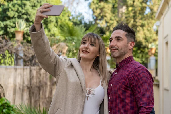 Jovem casal caucasiano tomando uma selfie com o smartphone — Fotografia de Stock
