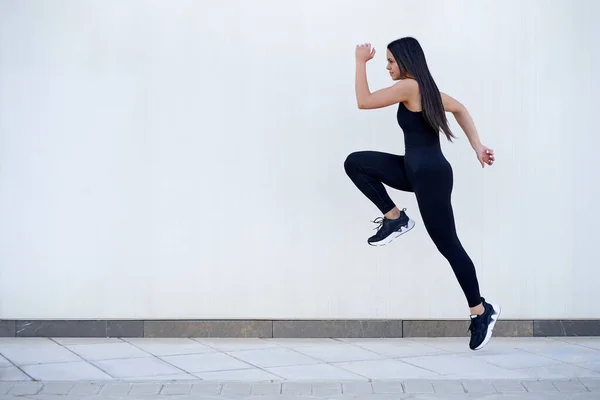 Νεαρή γυναίκα με γυμνασμένο σώμα πηδάει και τρέχει — Φωτογραφία Αρχείου