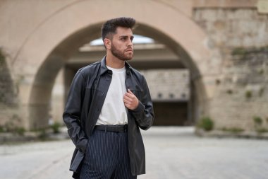 Siyah deri ceket giymiş, sakallı, beyaz bir adam.