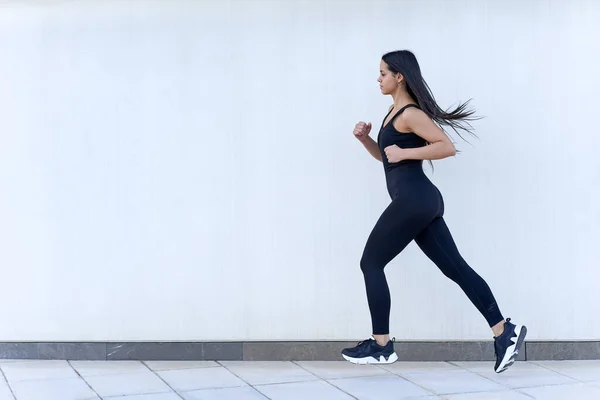 Mladá žena s fit tělo běží ve sportovním oblečení — Stock fotografie
