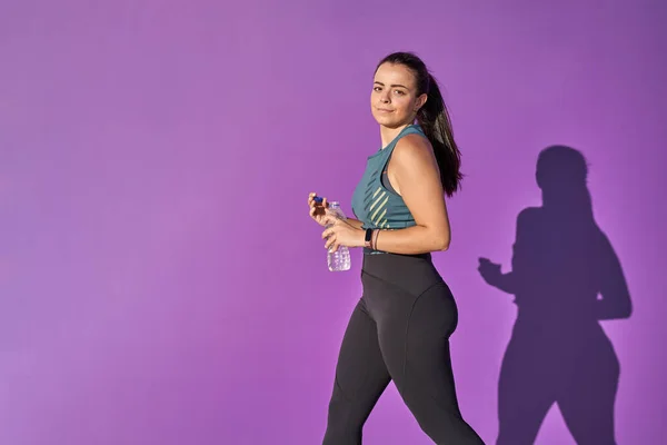 Young woman with fit body with a bottle of water. — Stock Photo, Image