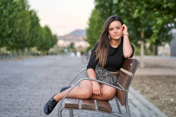 Young woman sitting on a bench. Urban concept
