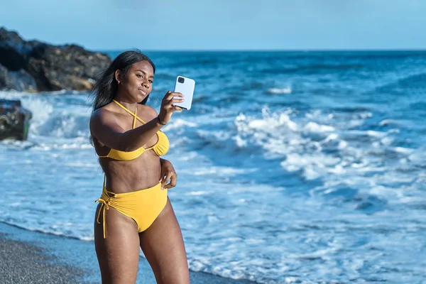 Afro-américaine prend un selfie sur la plage en bikini jaune — Photo