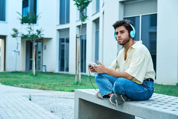 Задумчивый человек во время прослушивания музыки с планшетами и наушниками — стоковое фото