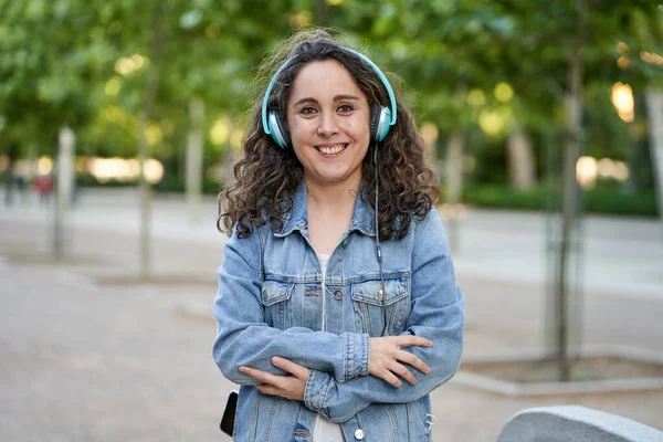 Жінка слухає музику зі своїми навушниками, підключеними до її смартфона — стокове фото