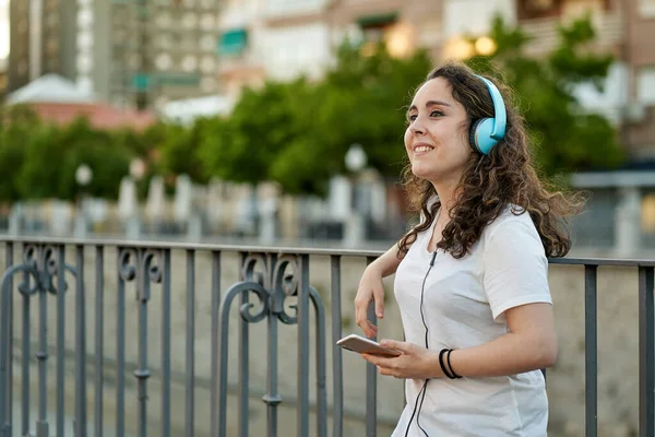 Femme écoute de la musique avec son casque connecté à son smartphone — Photo