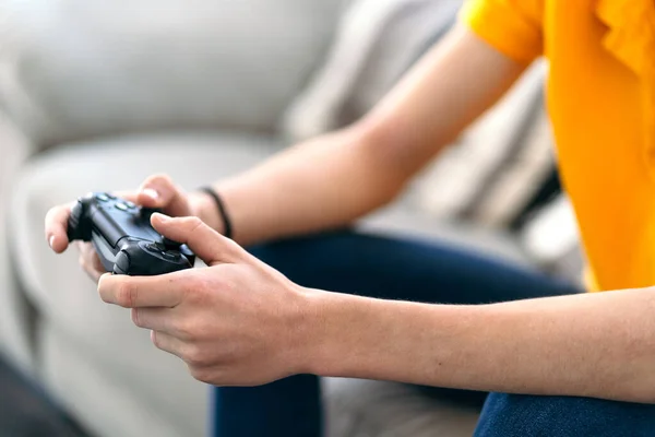 Detalhe da mão com o joystick de um cara jovem jogando um jogo no console em sua sala de estar — Fotografia de Stock