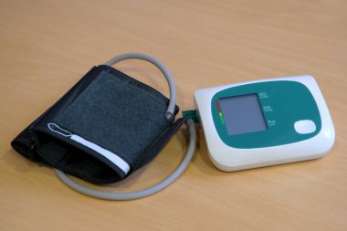 Basınç göstergesi. Masada dijital tansiyon monitörü var. Kan basıncını ölçmek için tıbbi tonometre. Otomatik dijital tansiyon monitörü