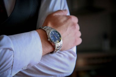 Beyaz gömlekli, siyah takım elbiseli ve renkli kravatlı bir adama yaklaş. Bileğinde saat olan damat. Damadın fotoğraf çekimi. Düğün fotoğrafları. İşadamı